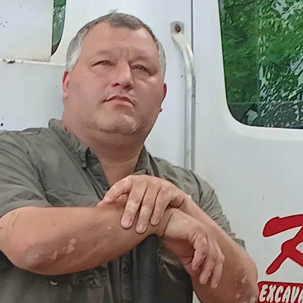 Kevin Kyser standing beside a K and K Septic truck